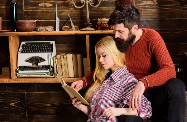 Couple in wooden vintage interior enjoy poetry. Romantic evening concept. Lady and man with beard on dreamy faces with book, reading romantic poetry. Couple in love reading poetry in warm atmosphere — Stock Photo, Image