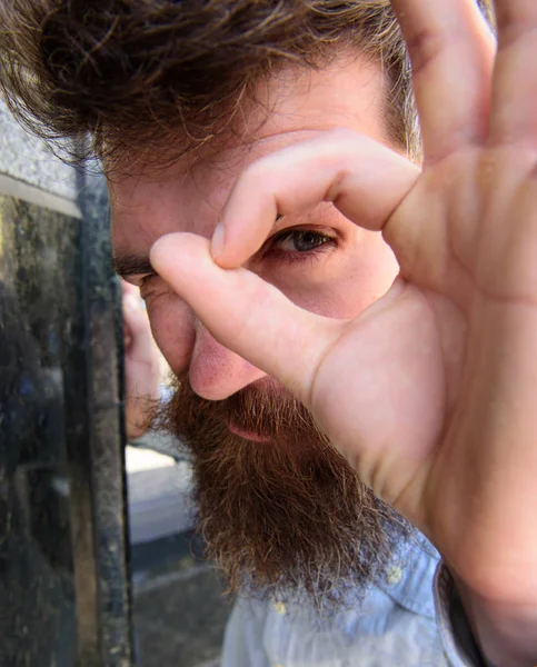 Concept d'observation. Le type a l'air suspect par un geste correct, de près. Hipster avec les cheveux ébouriffés regardant, observant, regardant. Homme barbu sur un visage réfléchi et suspect, fond de marbre noir — Photo