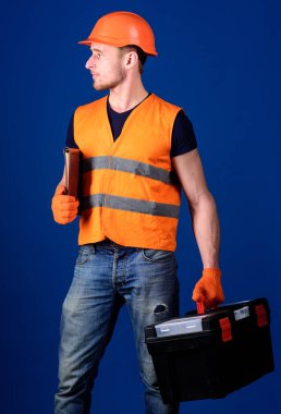 Kask, kask içinde adam araç kutusu ve klasör belgeler, mavi arka plan ile tutar. Tamirci çalışmaya hazır. İşçi, repairer, Oluşturucu araçları ile rüya gibi yüz taşır duruma. Onarım hizmet anlayışı