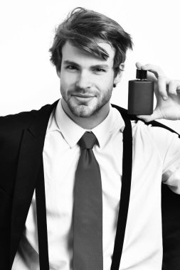 Beyaz adam parfümle poz veriyor.