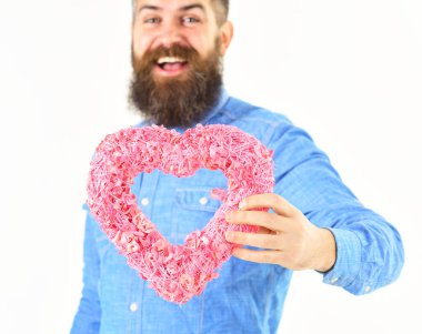 Pembe kalp ayakta beyaz arka plan üzerinde veren yakışıklı adam.