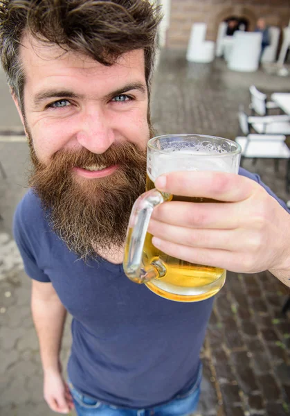 Um tipo a descansar com cerveja gelada. Hipster no rosto sorridente bebendo cerveja ao ar livre. Conceito de cerveja. Homem com barba e bigode segura vidro com cerveja enquanto relaxa no terraço do café — Fotografia de Stock