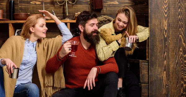 Homens e mulheres com rostos felizes a discutir e a beber vinho quente. Os amigos se divertem, falando e bebendo bebidas quentes no interior de madeira. Conceito de Soulmates. Os amigos passam o lazer no interior acolhedor — Fotografia de Stock