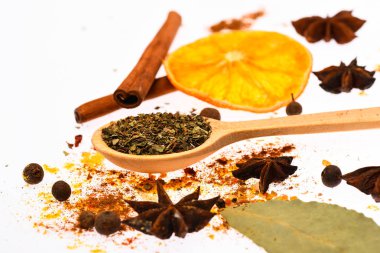 Baharat seti hazırlamak için mulled şarap ya da sıcak içecek, yakın çekim. Baharat Seti kavramı. Sıcak içecekler baharat seti. Kaşık ile baharat, kurutulmuş portakal, tarçın, kakule ve beyaz zemin üzerine Hindistan cevizi