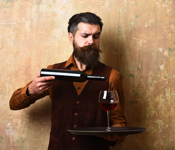 Camarero vierte vino tinto en vaso de botella en bandeja —  Fotos de Stock