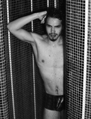 Yakışıklı kaslı seksi adam duşta yıkanıyor.