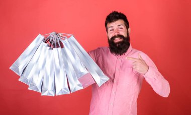 Sakal ve bıyık alışveriş torbaları, kırmızı arka plan işaret olan adam. Mutlu yüz hipster bağımlısı alışveriş veya Alışverişkoliğin. Satış sezon indirimlerle alışveriş adam. Alışveriş kavramı