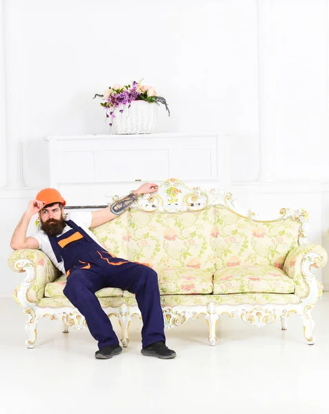 Trabajador barbudo sentado en un sofá antiguo aislado sobre fondo blanco. Cansado mover disfrutando de un pequeño descanso del trabajo — Foto de Stock