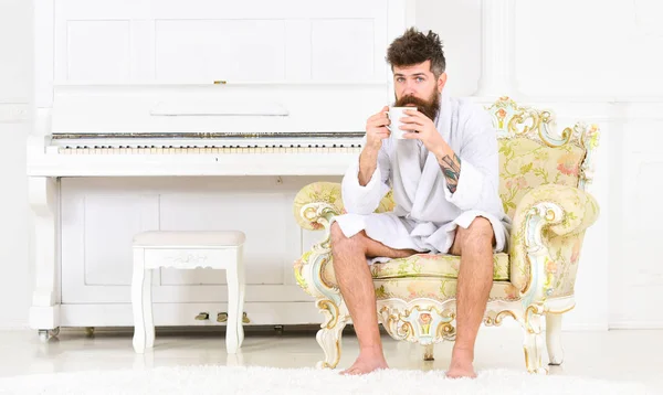 Розслаблений хлопець п'є чай або каву. Багатий бізнесмен у білій кімнаті готелю. Ранковий ранок перед роботою — стокове фото