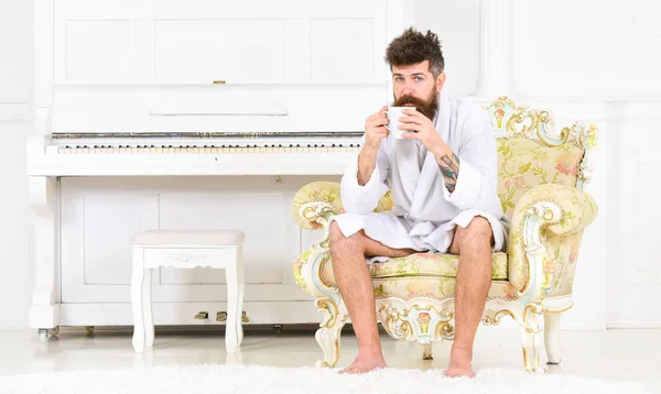 Relaxed guy drinking tea or coffee. Rich businessman in white hotel room. Serene morning before work — Stock Photo, Image