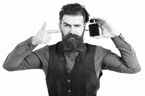 Homem barbudo segurando perfume com rosto sério — Fotografia de Stock