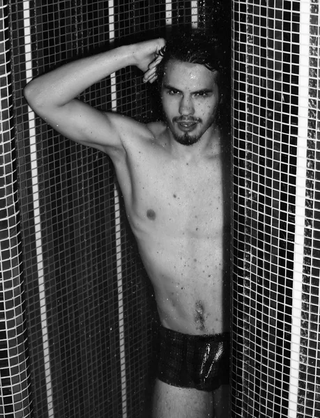 Yakışıklı kaslı seksi adam duşta yıkanıyor.