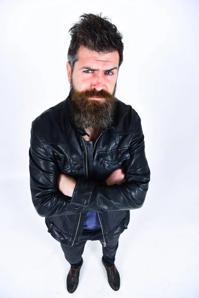 Hombre con barba y bigote en cara estricta mirando a la cámara. Macho usa chaqueta de cuero, fondo blanco. Ropa de hombre y concepto de moda. Hipster se ve serio mientras posando en traje elegante — Foto de Stock