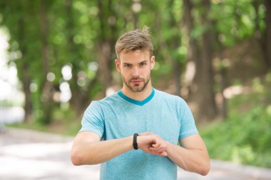 Adam atlet sıkı yüz fitness izci, Doğa arka plan kurma. Atlet ile kıl fitness izci veya adım sayar. Sporcu pedometre gadget ile eğitim. Spor araç konsepti