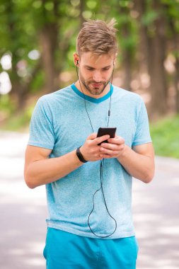 Adam atlet fitness İzleyicisi ile akıllı telefon app, Doğa arka plan kurma meşgul yüz. Sporcu pedometre gadget ile eğitim. Atlet fitness izci veya adım sayar. Spor araç konsepti