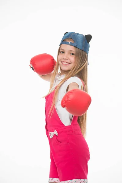 Lycklig flicka i boxning handskar isolerade på vitt. Lilla barnet ler innan träning eller träning. Kid idrottsman i fashionabla cap. Mode, stil och trend. Sportaktivitet och energi — Stockfoto