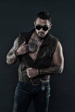 Dövme göğüs ve kollar ile moda maço. Moda stil ve eğilim. Tıraşsız yüzündeki sakallı dövme modeli. Pazı ve triceps dövmeli adam. Sakallı adam trendy güneş gözlüğü, vintage filtre