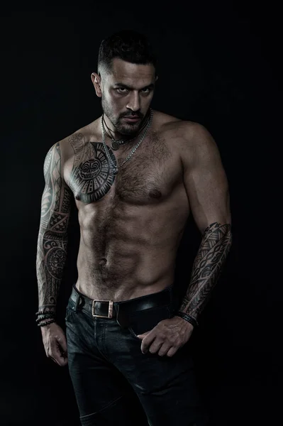 Modello tatuaggio con sei pack e ab. Uomo barbuto con corpo tatuato. Uomo con torso nudo sexy in jeans. Atleta o sportivo con petto e pancia muscolosi. Sport o fitness e cura del corpo, filtro vintage — Foto Stock