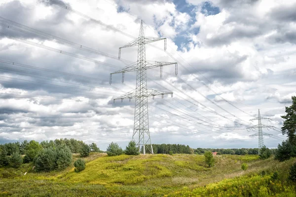 Torres de energia na paisagem natural. Torres de transmissão no céu nublado. Estrutura de pilão de eletricidade com linhas de energia. Posto de alta tensão ao ar livre. Energia e ecologia — Fotografia de Stock