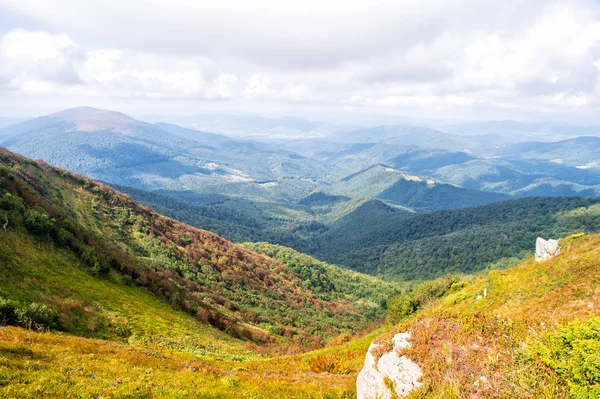 Hill in foggy sunny mountains. Scenery landscape of hills in sunlight with clouds. Travel and wanderlust concept. Landscape of mountains and valleys in summer. Mountains covered with green forest — Stock Photo, Image