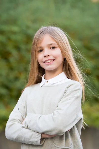 Frisyr och hår vård koncept. Flicka på leende ansikte poserar med långt hår, grön naturliga bakgrund. Kid flicka med långt hår ser bedårande. Flickan gillar att titta söta, snygga och moderiktiga — Stockfoto