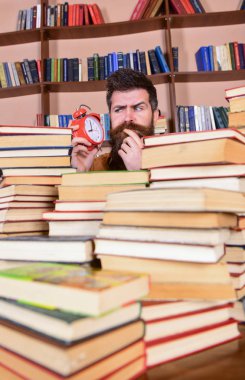 Öğretmen ya da sakal Kitaplığı'nda eğitim ile öğrenci. Adam, çalar saat ile kitap yığınları dışarı bakmak bilim adamı. Adam düşünceli yüz saat, raflardan arka plan üzerinde seyir. Son Tarih kavramı