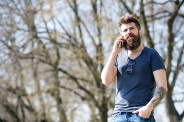 Sakallı hippi üstünde hareket eden telefon açık konuş. Sakal ve bıyık konuşurken, Doğa arka plan, defocused sıkı yüzünde olan adam. Cep telefonuyla konuşan sakallı adam. İletişim kavramı