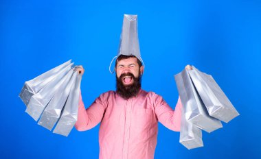 Pembe gömlek ve mavi arka plan üzerinde izole kafasında gümüş çanta trendy sakallı adam. Alışveriş şampiyon kazanan ilk ödül yarışması, mutluluk kavramı. Adam zevk satış zaman sakallı.