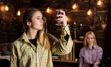 Arkadaşlar sıcak bir atmosferde, ahşap iç mulled şarap tadını çıkarın. Rahat rahatlatıcı, defocused kareli giysiler yüzlerine arkadaşlar. Dinlenmek ve rahatlamak kavramı. Rahatlatıcı ve mulled şarap içme kızlar