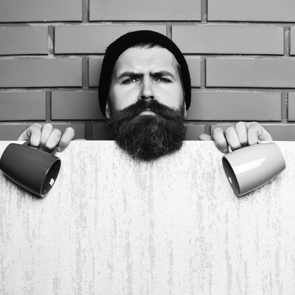 Barbu brutal hipster caucasien avec feuille de papier et tasses — Photo