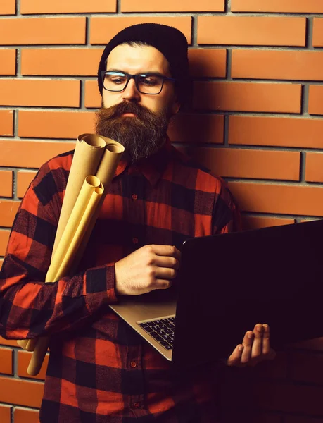 Szakállas brutális kaukázusi hipster gazdaság laptop és kézműves papír — Stock Fotó