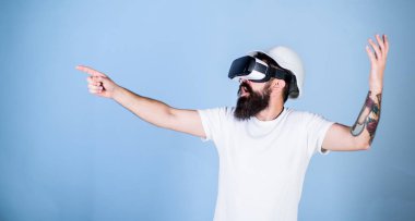 Hipster kask içinde sanal gerçeklik mühendisi olarak çalışıyor. 3D tasarım konsepti. Mimar ya da sanal gerçeklik gözlüklü. Açık mavi renkli parmak ile işaret Vr bardaklarda sakallı