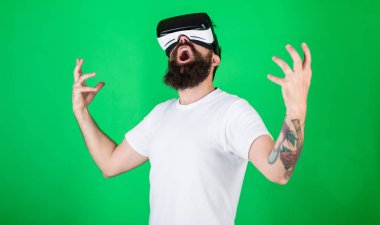 Güç kavramı. Hipster yüz eller güçlü iken yetiştirme bağırarak üzerinde etkileşim içinde sanal gerçeklik. Vr gözlük, yeşil arka planda sakallı adam. Adam kafa monte ekran ile etkileşim içinde Vr