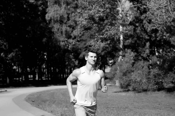 El hombre corre en el parque en el soleado día de verano — Foto de Stock