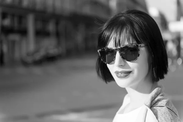 Женщина в красных губах в солнечных очках ходит по улице — стоковое фото