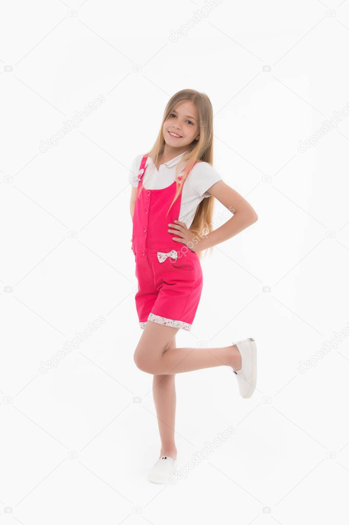 Kid model in fashionable overall. Small girl smile in pink jumpsuit isolated on white. Child smiling with long blond hair. Fashion style and trend. Happy childhood and childcare
