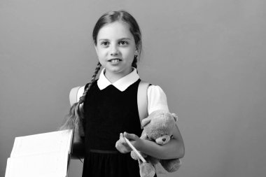 Okul üniformalı, örgülü ve pembe sırt çantalı bir öğrenci.