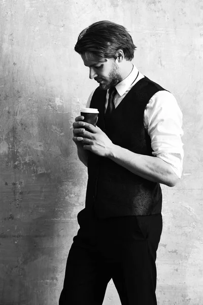 Ранкова кава, молодий серйозний бізнесмен тримає паперовий стаканчик — стокове фото