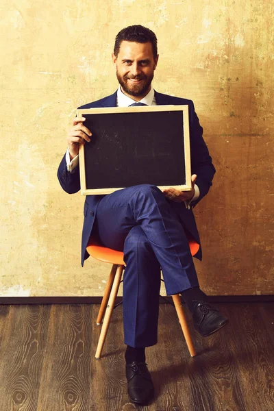 Hombre de negocios u hombre feliz sosteniendo una pizarra . — Foto de Stock