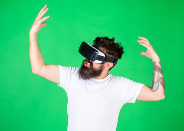 Hippi ilham ifade ile modern aracı Vr keşfetmek ile. VR gadget kavramı. Vr gözlük, yeşil arka planda sakallı adam. Adam kafa monte ekran ile etkileşim içinde sanal gerçeklik