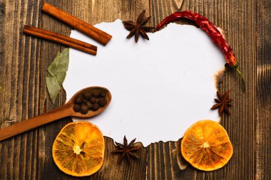 Baharatlar, beyaz kağıt mutfak otlar yatıyordu. Tarçın, kurutulmuş portakal ve anasonu lay boş kağıt, tarifi, çevresinde yer kopyalayın. Mutfak tarifi kavramı. Kağıt ahşap arka plan üzerinde