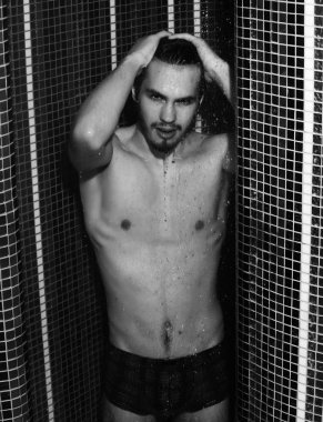 Yakışıklı kaslı seksi adam duşta yıkanıyor.