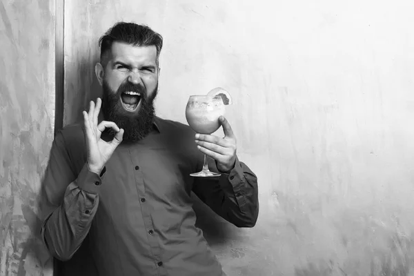 Brutální kavkazský hipster držící čerstvý tropický alkoholický koktejl — Stock fotografie
