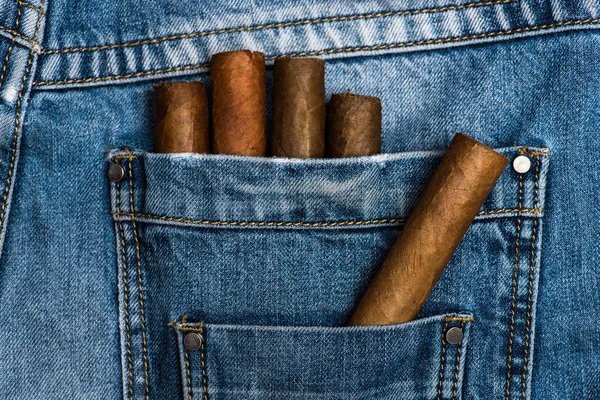Τσέπη του τζιν στελεχωμένο με πούρα, τζιν φόντο. Πούρα στην πίσω τσέπη του τζιν. Έννοια συνήθειες. Συνήθεια να καπνίζετε ελίτ καπνού. Συλλογή των ελίτ πούρα — Φωτογραφία Αρχείου
