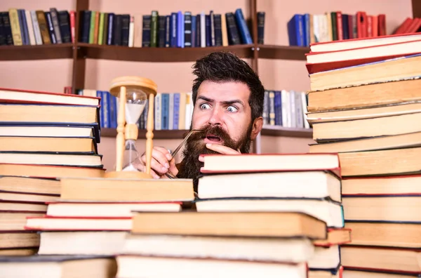 Dostum, bilim adamı kum saati görünüyor. Zaman akışı kavramı. Öğretmen ya da sakal Kitaplığı'nda eğitim ile öğrenci. Adam ciddi ve şok yüz izlerken zaman raflardan, arka planda gidiyor