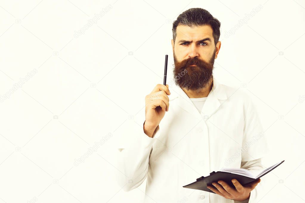 Bearded man, long beard. Brutal caucasian doctor or unshaven hipster, postgraduate student holding notebook with pen in medical gown isolated on white studio background. Medicine concept