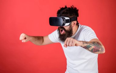 Hippi heyecanlı yüzündeki sürüş hızlı Bisiklet sanal gerçeklik ile modern dijital becerikli alet. Vr sakallı sürüş motosiklet, kırmızı arka plan gözlük. Sanal sürüş dersleri kavramı
