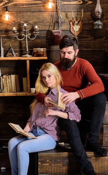 Casal apaixonado lendo poesia em ambiente acolhedor. Conceito de noite romântico. Senhora e homem com barba em rostos de sonho abraços e leitura de poesia romântica. Casal em madeira vintage interior desfrutar de poesia — Fotografia de Stock