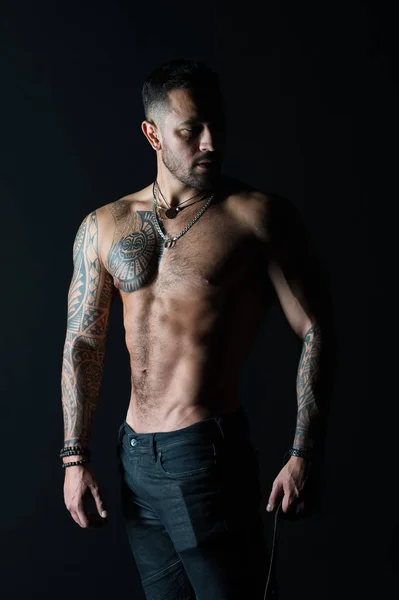 Tattoo model s sexy břicho. Muž s tetované paže a hrudníku. Vousatý muž se silným trupu. Sportovec nebo sportovec v módní džíny. Péče o tělo s fitness a sportu — Stock fotografie