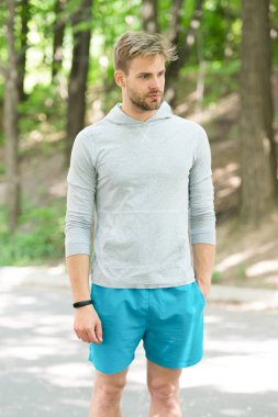 Sporcu pedometre gadget ile eğitim. Fitness izci kavramı. Atlet ile kıl fitness izci veya adım sayar. Adam atlet Spor donatımı, Doğa arka plan ile poz sıkı yüzünde